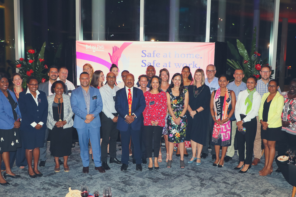 Group photo of all guests standing in front of pink banner at the Leadership Forum