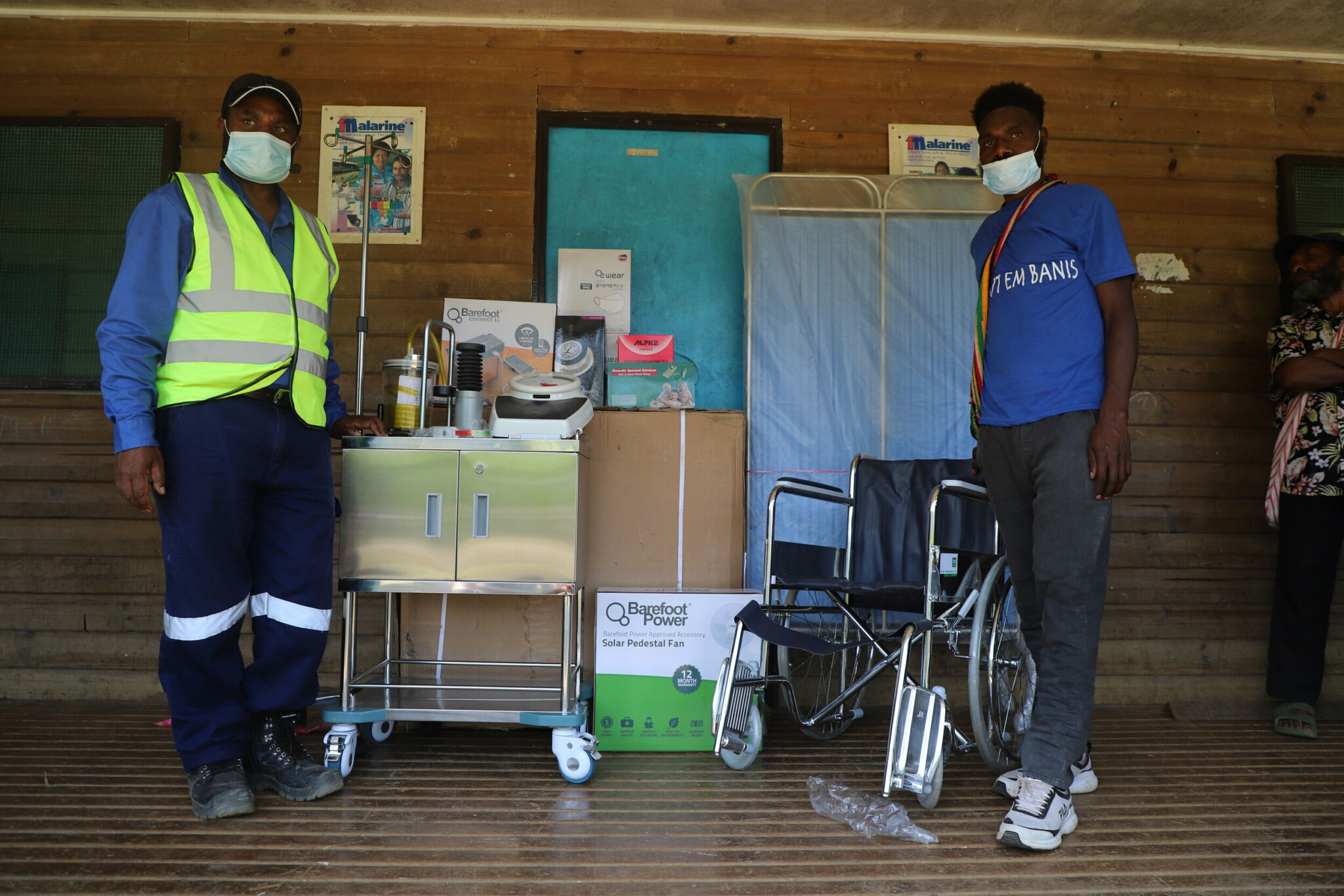 Health care workers stand around hospital equipment