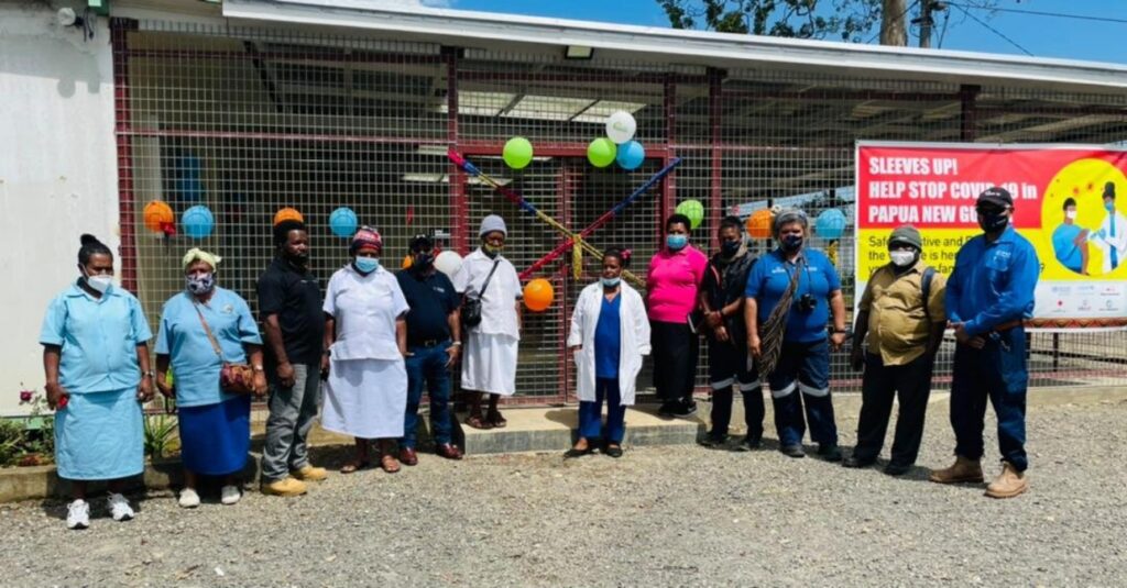 Hospital staff standing in front of new hospital building