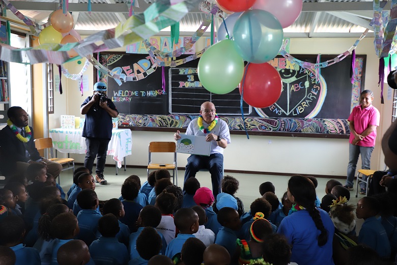 Oil Search Foundation Chairman Peter Botten reads to children at the Habare Literacy Library in Tari-Pori district, Hela province.