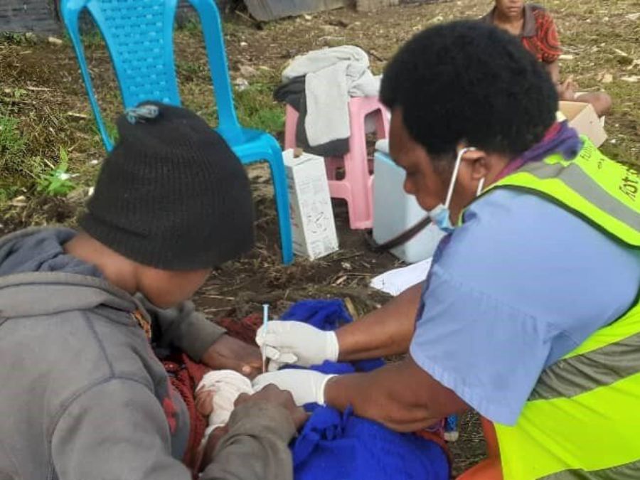 Health care working administering immunisation to newborn baby