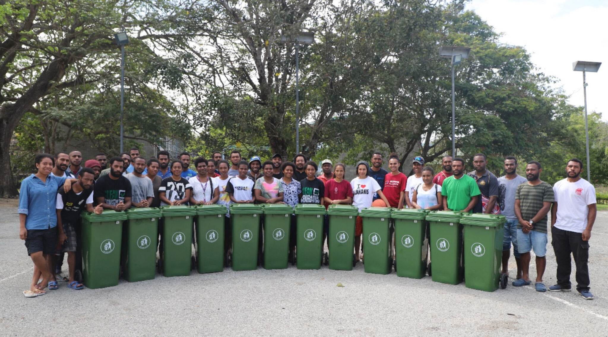 students standing with wheelie bins on campus