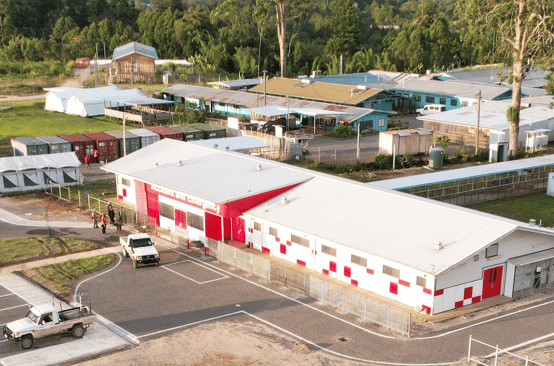 aerial drone shot of white and red Hela AE building